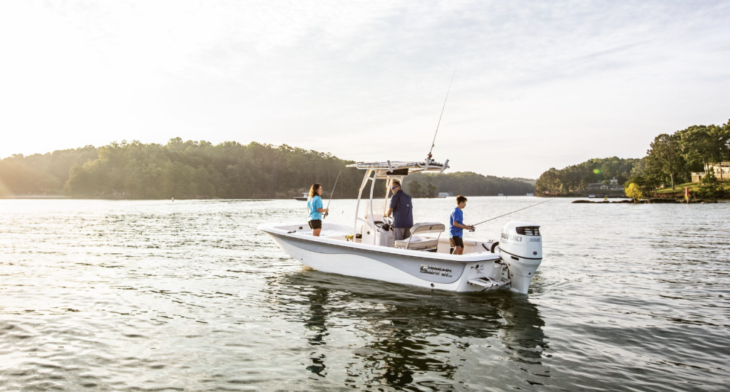 Profile of a Carolina Skiff boat with a single Suzuki engine floating with people fishing on board